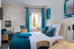 a bedroom with a large white bed with blue pillows at Le Mas du Terme in Barjac +119 photos