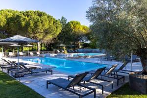 - une piscine avec des chaises longues et un arbre dans l'établissement Le Mas du Terme, à Barjac