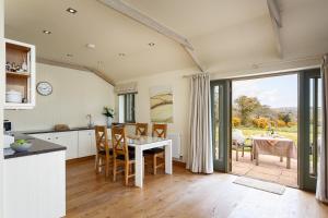 a kitchen and dining room with a table and chairs at The Granary at Cornish Barn Holidays in Truro