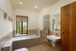 a bathroom with a tub and a sink at The Granary at Cornish Barn Holidays in Truro +32 photos