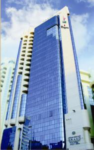 阿布達比的住宿－Grand Continental Hotel，一座高大的蓝色和白色建筑,有许多窗户