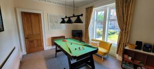a living room with a pool table and a window at Criffel Cottage in Dumfries