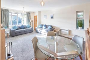 a living room with a glass table and a couch at Host & Stay - Baslow Road, Serviced Apartment in Totley