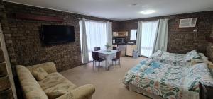 a bedroom with a bed and a brick wall at The SIM - Sussex Inlet Motel in Sussex inlet