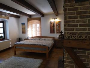 a bedroom with two beds and a brick wall at Forest Rustic Apartment Brdy in Buková