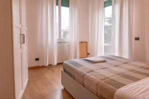 a bedroom with a bed and two large windows at Parea House 1 in Milan