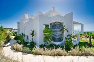 EsteponaAL-1112 2 Bed Alcazaba Lagoon的一座白色的房子，前面有棕榈树