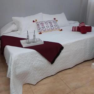 un letto bianco con un vassoio con due candele sopra di Rinconcito de Diana a Vecindario