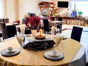 格涅茲諾的住宿－芬妮克絲酒店，上面有盘子和蜡烛的桌子