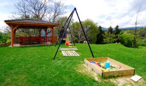 a swing set in a yard with a sandbox at Urthalerhof in Castelrotto