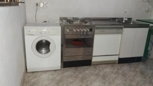 a kitchen with a stove and a washing machine at Samaya Apartment with balcony in Hikkaduwa