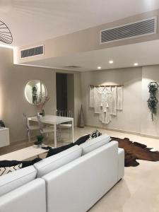 Jutta Deluxe 2,5-Bedroom-Apartment Mangroovy-M10 El Gouna في الغردقة: غرفة معيشة مع أريكة بيضاء وطاولة