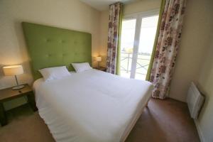 - une chambre avec un grand lit blanc et une fenêtre dans l'établissement Villa Bellagio Amboise by Popinns, à Amboise