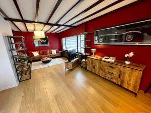 Il comprend un salon doté de murs rouges et d'une télévision. dans l'établissement La Pit Home, à Francorchamps