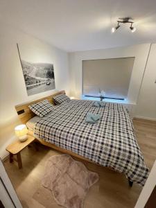 - une chambre avec un grand lit et une couverture en damier dans l'établissement La Pit Home, à Francorchamps