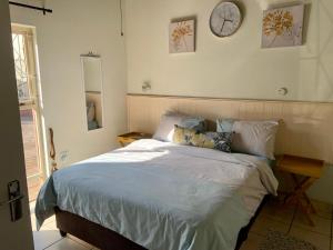 1 dormitorio con 1 cama y reloj en la pared en Seaview on Shelly, en Margate