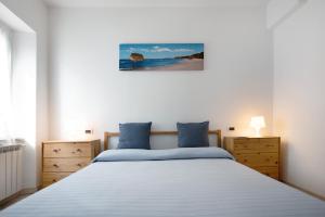 a bedroom with a large bed with blue pillows at Trilocale San Nazario in Varazze