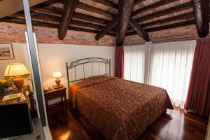 Residence Bertolini في بادوفا: غرفة نوم بسرير في غرفة بسقوف خشبية