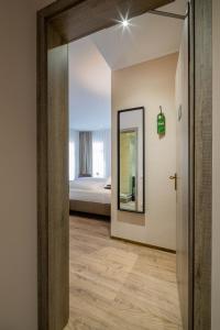 - un couloir avec un miroir et un lit dans l'établissement Hof Ehrenfels, à Mayence