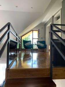 a staircase in a room with chairs and a table at Family resort TRAPISTI in Banja Luka