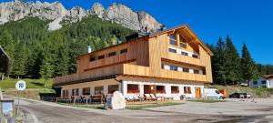 a large building with a mountain in the background at Chalet Alpenrose in Misurina