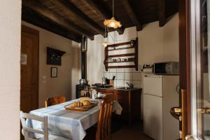 a kitchen with a table and a white refrigerator at Albergo Diffuso Polcenigo Ciasa VeS in Polcenigo