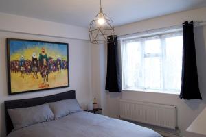 a bedroom with a bed and a painting on the wall at Modern 1 Bedroom in Shadwell with Balcony in London