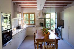 a large kitchen with a wooden table and chairs at Villa Luz Casa Valenciana in Alzira