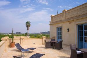 a patio with chairs and a table and a building at Villa Luz Casa Valenciana in Alzira