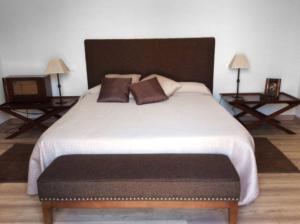a bedroom with a large white bed with two tables at Villa Luz Casa Valenciana in Alzira