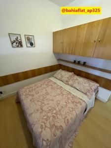 a bedroom with a bed with a wooden headboard at Flat à Beira Mar na Barra in Salvador