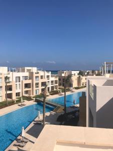 einen Blick auf den Pool vom Balkon eines Gebäudes in der Unterkunft Jutta Deluxe 2-Bedroom-Apartment Mangroovy-M7 El Gouna in Hurghada