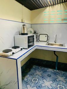 a small kitchen with a sink and a microwave at Free Concept Beach Resort in Srithanu