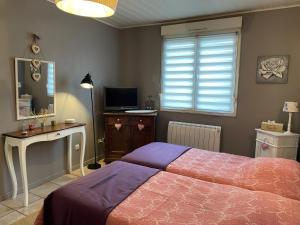 Jardin Secret au Cœur de la Dourd’halie في سانت أفولد: غرفة نوم بسرير ومكتب وتلفزيون