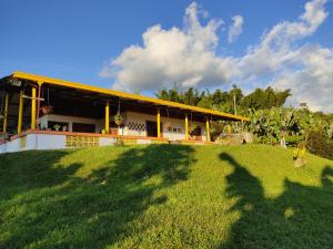 una casa en una colina con un campo verde delante de ella en Finca La Antigua. finca tradicional Cafetera en Jardín