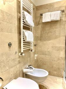bagno con servizi igienici, lavandino e asciugamani. di Tito Suite a Roma