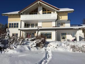 uma casa com neve em frente em Ferienwohnung-Rottachseeblick em Sulzberg