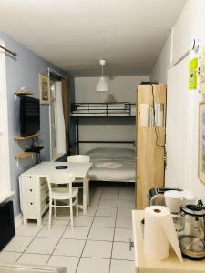 eine kleine Küche mit einem Tisch und einem Etagenbett in der Unterkunft Joli Studio proche plage et centre avec parking in Wimereux