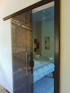 a glass door with a reflection of a bed in a room at Estalagem Sol de Boipeba in Ilha de Boipeba