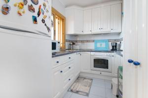 Biała kuchnia z białymi szafkami i lodówką w obiekcie 105 Beach View - Alicante Holiday w mieście Torrevieja