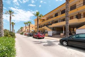 ulica z samochodami zaparkowanymi przed budynkiem w obiekcie 105 Beach View - Alicante Holiday w mieście Torrevieja