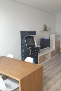 Habitación con escritorio, ordenador y TV. en UrbanLux Feria, en Albacete