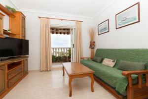 un salon avec un canapé vert et une télévision dans l'établissement 114 Sea Views Dream - Alicante Holiday, à Torrevieja