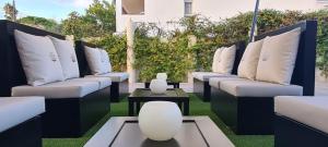 a row of white couches sitting on a lawn at 6 Bis HOTEL in Castelldefels +39 photos