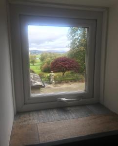 a window with a view of a garden outside at 1-Bed luxury studio Apartment Cockermouth in Cockermouth
