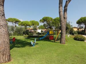 a young child playing in a playground between two trees at Villaggio Danubio in Bibione