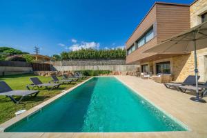a swimming pool in the backyard of a house at Villa Mestres Playa de Aro in Platja  d'Aro