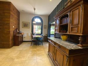 una cocina con armarios de madera y una mesa. en Betsey Trotwood. Historic stylish 2-bed cottage., en Blundeston