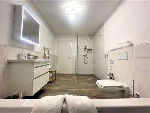 une salle de bain blanche avec toilettes et douche dans l'établissement Ferienwohnung am Park, à Badenweiler 10 autres photos