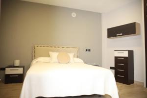 um quarto com uma cama branca e uma cómoda em Caño em Córdoba